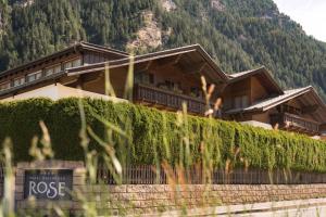 ein Chalet in den Bergen mit einem Schild davor in der Unterkunft Hotel & Residence Rose in Sterzing