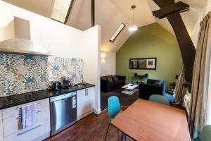 a kitchen and living room with a table and chairs at Chapel Apartments in Dunedin
