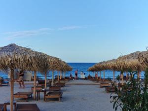a row of chairs and straw umbrellas on a beach at La Ion Residence 1 in Năvodari