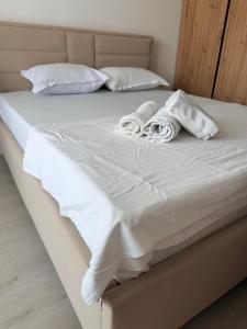 a bed with white sheets and towels on it at La Ion Residence 1 in Năvodari