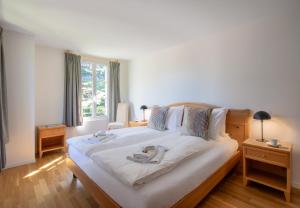 a bedroom with a large white bed with shoes on it at Chalet Mittaghorn Apt 7 in Wengen