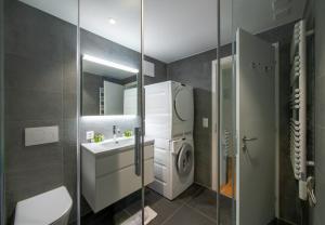 a bathroom with a washing machine and a sink at Chalet Mittaghorn Apt 7 in Wengen +35 photos