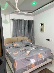 a bedroom with a bed with a gray comforter at TGS home in Lomé