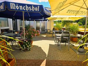 a patio with tables and chairs with umbrellas and plants at 'Schlabecks - Fränkischer Hof' - - - Garni-Hotel-Pegnitz in Pegnitz