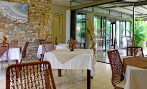 a restaurant with tables and chairs and a stone wall at The Elegant Guesthouse in Windhoek