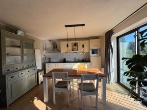 a kitchen with a wooden table and chairs and a window at Apartment Osso 3 in Arnhem