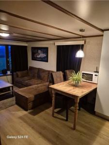 a living room with a couch and a table at Chalet te huur op Camping de Kleine Wielen te Leeuwarden in Leeuwarden