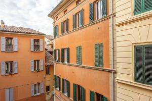 a group of buildings with green and orange windows at De'Giudei, Bologna by Short Holidays in Bologna