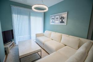 a living room with a white couch and a table at STARRY Residence Suite Hakuba Happo-one in Hakuba