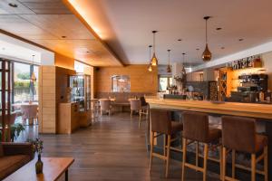 ein Restaurant mit Bar, Stühlen und Tischen in der Unterkunft Hotel & Residence Rose in Sterzing