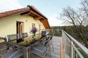 balkon domu z krzesłami i stołem w obiekcie Ferienwohnung Mayrhofer w mieście Hofkirchen im Mühlkreise