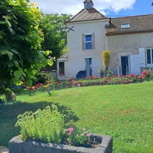 a house with flowers in front of a yard at Dans colombier proche de Vichy parking privé in Vichy