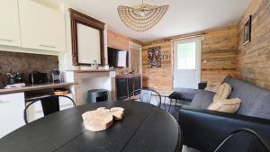 a dining room with a table and a living room at Domaine Les Tourelles - La petite maison in Caffiers