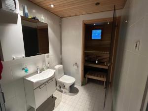 a white bathroom with a sink and a toilet at Levistar II 1414 in Kittilä