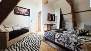 a bedroom with a bed and a couch in a room at Domaine Les Tourelles - La petite maison in Caffiers
