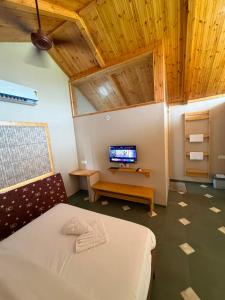 a bedroom with a bed and a flat screen tv at Dream Habitat in Wādhiware +10 photos