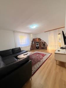 a living room with a black couch and a red rug at Vila Noor Sarajevo in Sarajevo