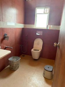 a bathroom with a toilet and a sink and a window at Dream Habitat in Wādhiware
