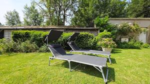 three chairs sitting in the grass in a yard at Domaine Les Tourelles - La petite maison in Caffiers