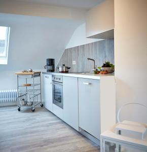 - une cuisine blanche avec évier et cuisinière dans l'établissement Ferienwohnung Schwarz, à Mayen