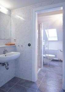 La salle de bains blanche est pourvue d'un lavabo et de toilettes. dans l'établissement Ferienwohnung Schwarz, à Mayen