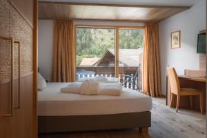 ein Hotelzimmer mit einem Bett und einem großen Fenster in der Unterkunft Hotel & Residence Rose in Sterzing