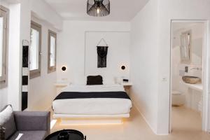 a white bedroom with a bed and a couch at Black Shade Suite in Fira +18 photos