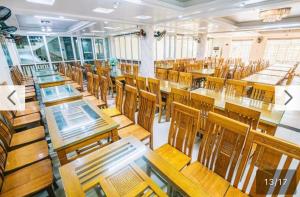 an empty classroom with wooden tables and chairs at Chinh Thuỷ Hotel in Sầm Sơn