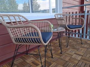 three wicker chairs and a table on a porch at Levistar II 1414 in Kittilä