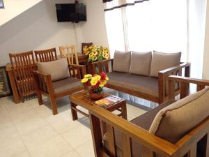 a living room with chairs and a table with flowers on it at Sobasee Holiday Bungalow in Kandy +14 photos