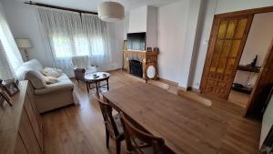 a living room with a table and a couch at Chalet del Daniel en La Calabaza in Aranda de Duero