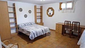 a bedroom with a bed and a table and a desk at Chalet del Daniel en La Calabaza in Aranda de Duero +6 photos