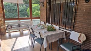 a porch with a table and chairs and a window at Chalet del Daniel en La Calabaza in Aranda de Duero