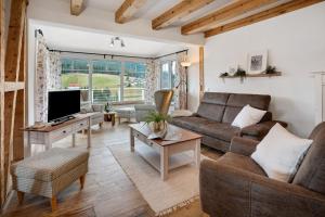 a living room with a couch and a tv at Villa Pauline in Baiersbronn