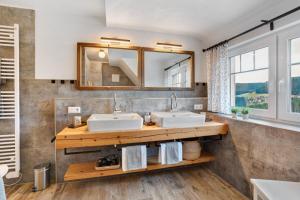 a bathroom with two sinks and a mirror at Villa Pauline in Baiersbronn +54 photos