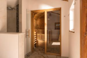 ein Badezimmer mit einer Glastür, die zu einem Kleiderschrank führt in der Unterkunft Hotel & Residence Rose in Sterzing + 23 Fotos