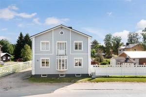 a gray house with a white fence at Central City nest in Haparanda