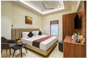 a hotel room with a bed and a chair and a table at Hotel Heritage Suites in New Delhi