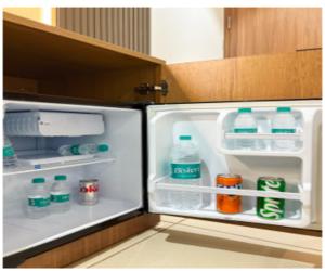 an open refrigerator with bottles of water and milk at Hotel Heritage Suites in New Delhi +30 photos