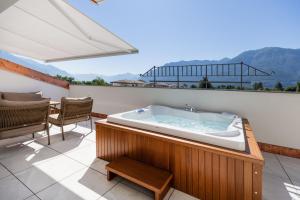 a hot tub on a balcony with a table and chairs at Villa Delta - Parkhotel Delta in Ascona