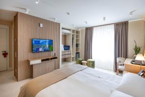a hotel room with a large bed and a television at Villa Delta - Parkhotel Delta in Ascona