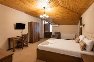 a bedroom with a bed and a desk and a television at Hotel Imperial House in Tbilisi City