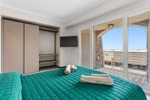 a bedroom with a green bed with towels on it at SeaFrontBonassola in Bonassola
