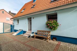 a blue house with a bench and a window at Ferienwohnung Blaues Haus in Ubstadt-Weiher