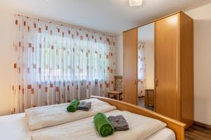 a bedroom with a bed with two green towels on it at Fuchsmichelhof 2 in Seebach