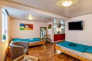 a living room with two beds and a tv at Ferienwohnung Blaues Haus in Ubstadt-Weiher