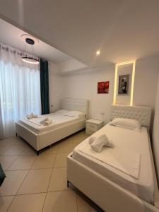 a bedroom with two beds and a window at Hotel Kristal Borsh in Borsh
