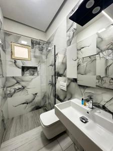 a bathroom with a white toilet and a sink at Hotel Kristal Borsh in Borsh +59 photos