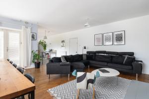 a living room with a black couch and a table at Finest Retreats - Walltree House in Brackley
