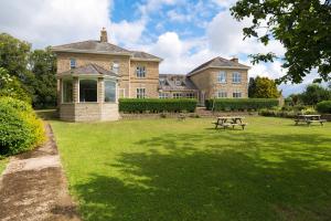a large brick house with a picnic table in the yard at Finest Retreats - Walltree House in Brackley